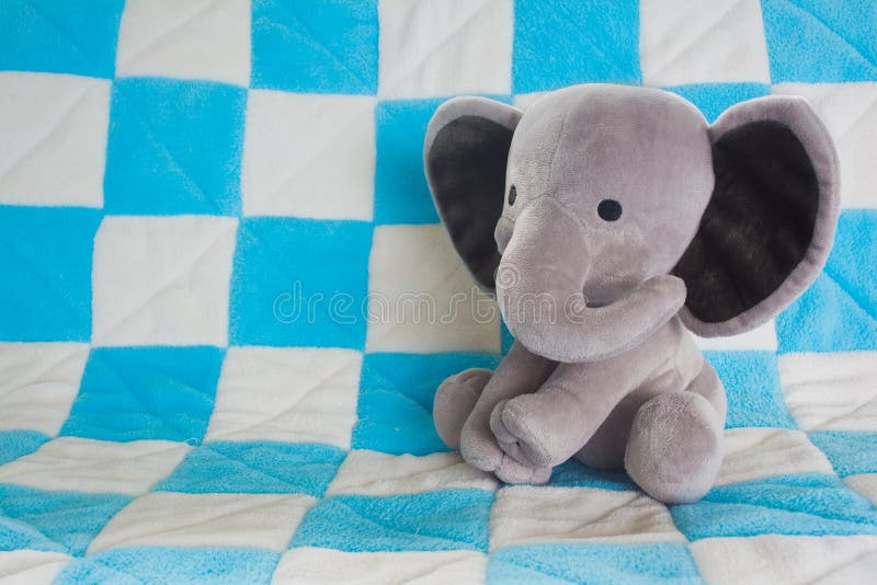 Cute Baby Elephant Stuffed Animal on a Blue Checkered Blanket royalty free stock photography Cute Baby Elephant Stuffed Animal on a Blue Checkered Blanket royalty free stock photography