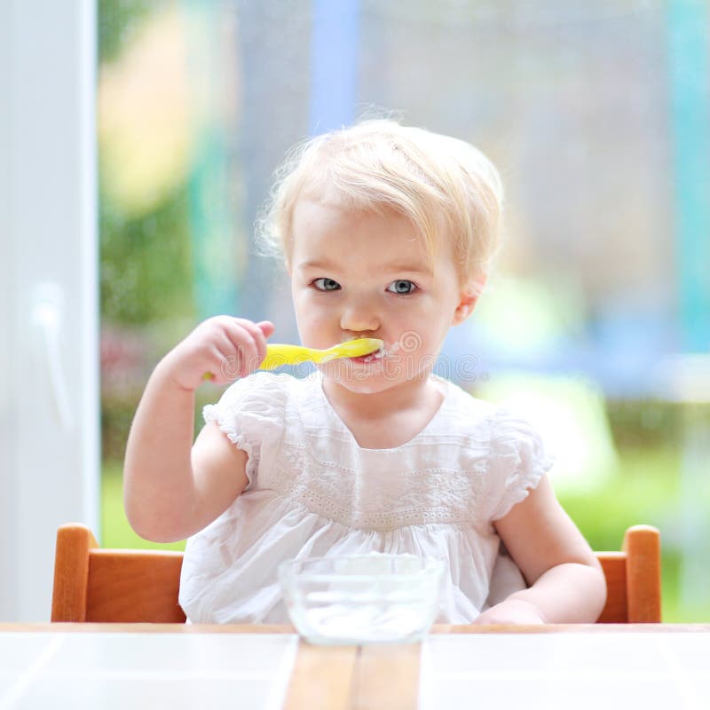 Cute Baby Girl Eating Yogurt From Spoon Stock Image ...