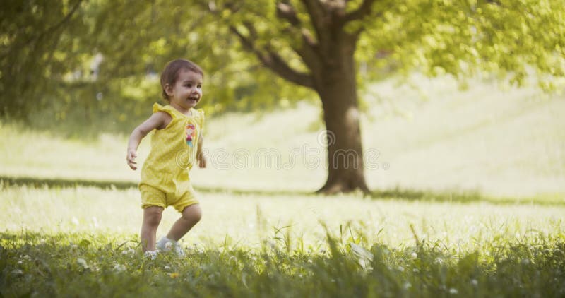 Cute baby girl exploring a park in late spring.