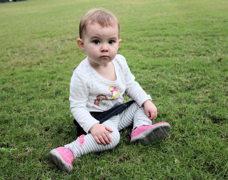 Cute baby girl on green grass