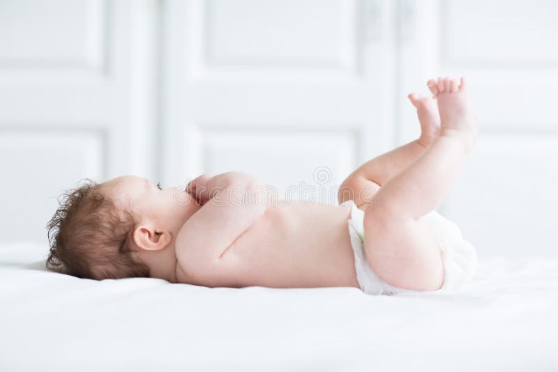 Cute baby playing with its legs and sucking on its hand royalty free stock photos Cute baby playing with its legs and sucking on its hand royalty free stock photos