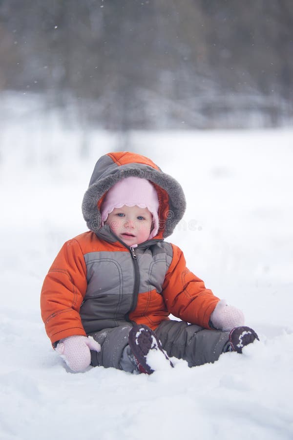 Cute baby sit on fresh snow in park