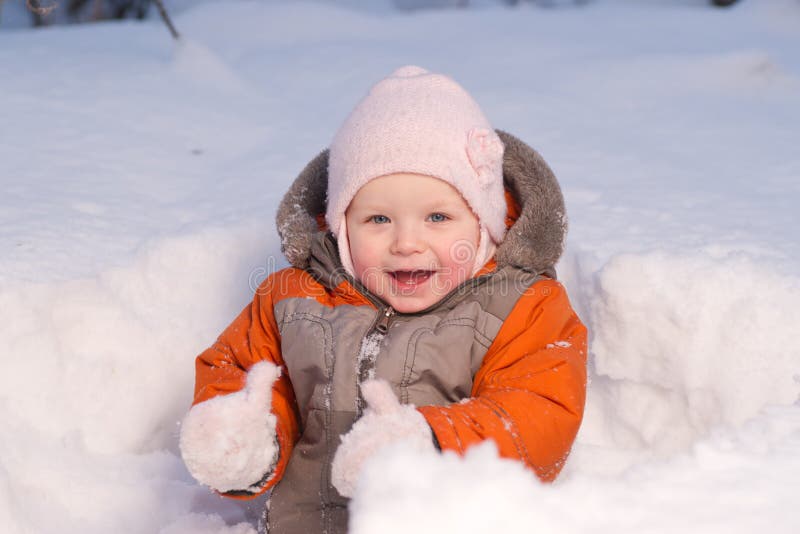 Cute baby sit in snow in forest and dig it