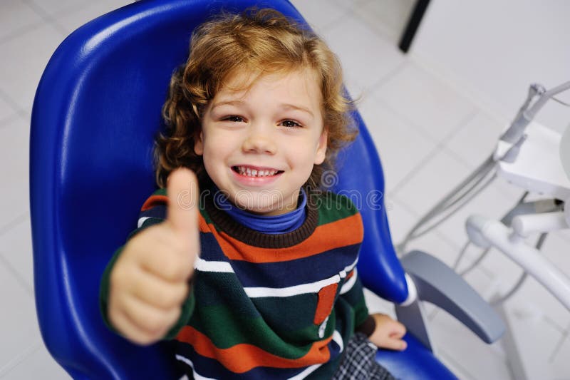 Cute baby in a striped sweater on reception at the dentist stock photo Cute baby in a striped sweater on reception at the dentist stock photo