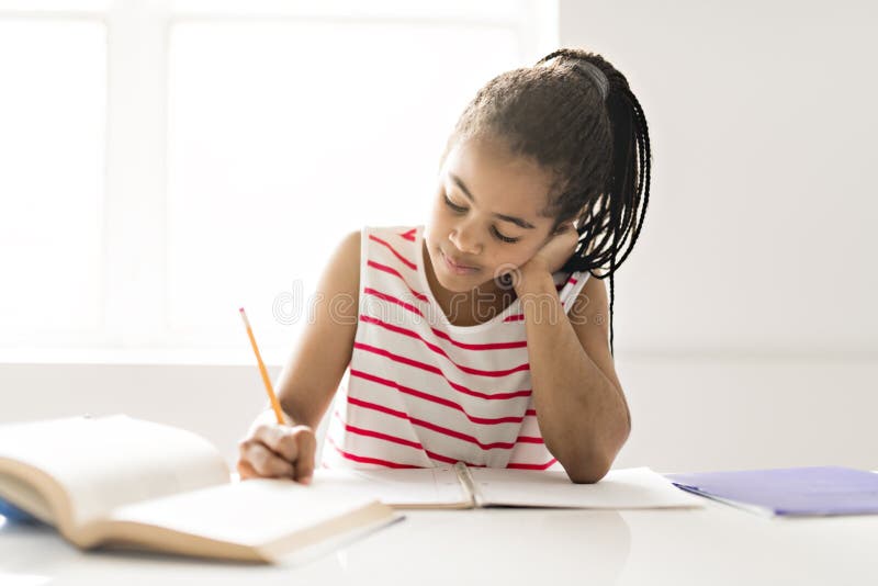 A cute Black girl doing homework at home