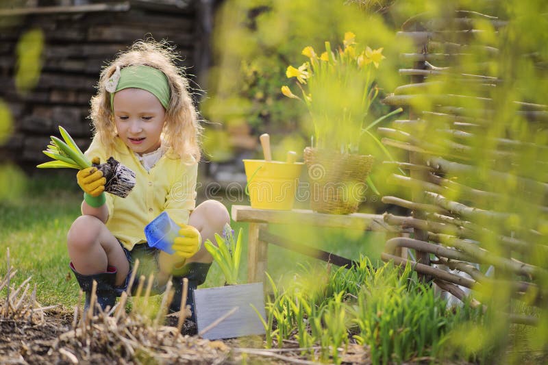 Cute blonde child girl having fun playing little gardener