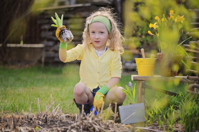 Cute blonde child girl having fun playing little gardener