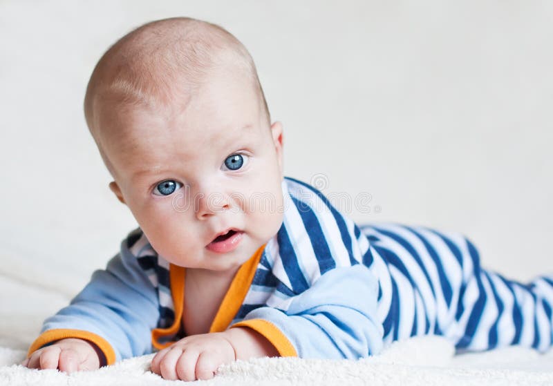 Cute blue-eyed baby boy looking at the camera on a white background