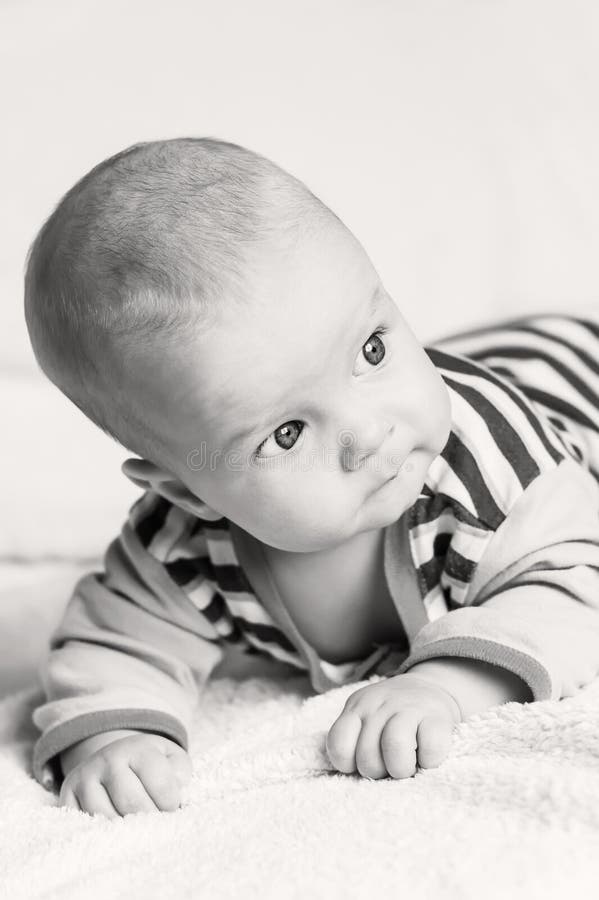 Cute blue-eyed baby boy looking to the right on a white background (black and white)