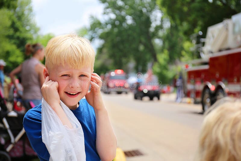 Cute Boy Child at Parade Plugging his Ears from the Loud Fire Truck Sirens royalty free stock photos Cute Boy Child at Parade Plugging his Ears from the Loud Fire Truck Sirens royalty free stock photos