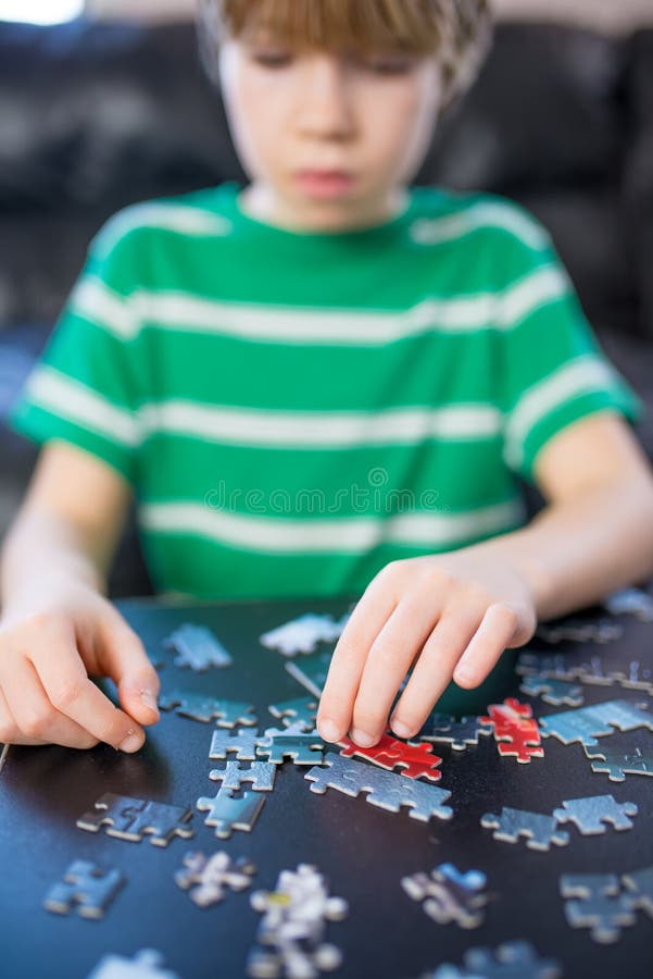 Cute boy doing a puzzle stock image. Image of assemble 87626991