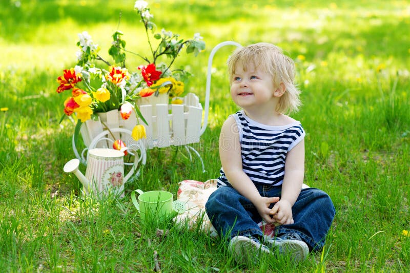 Cute boy in the garden with flowers