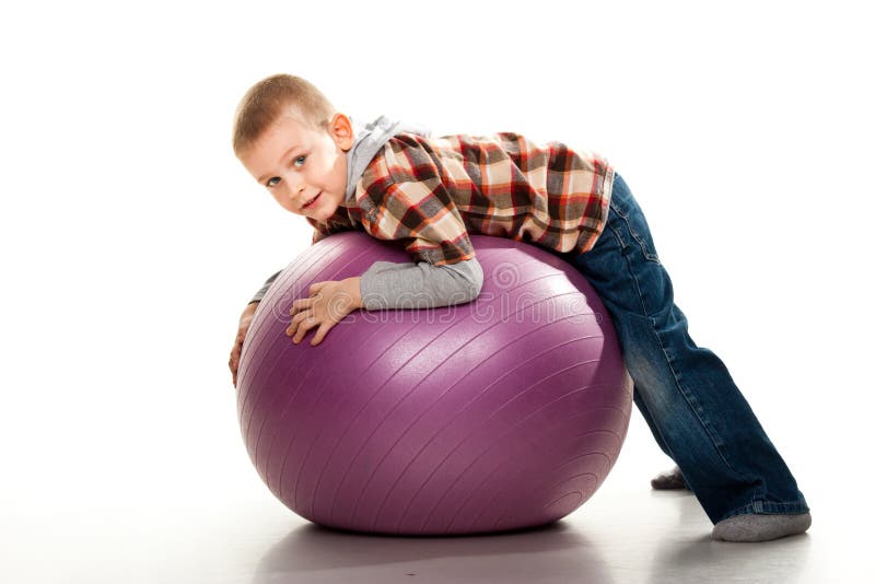 Cute boy playing with fit ball