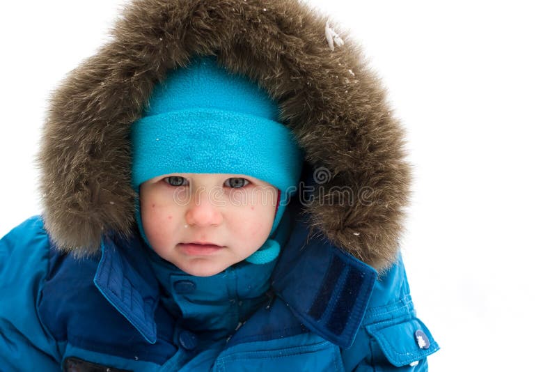 Cute boy sitting in snow outdoor