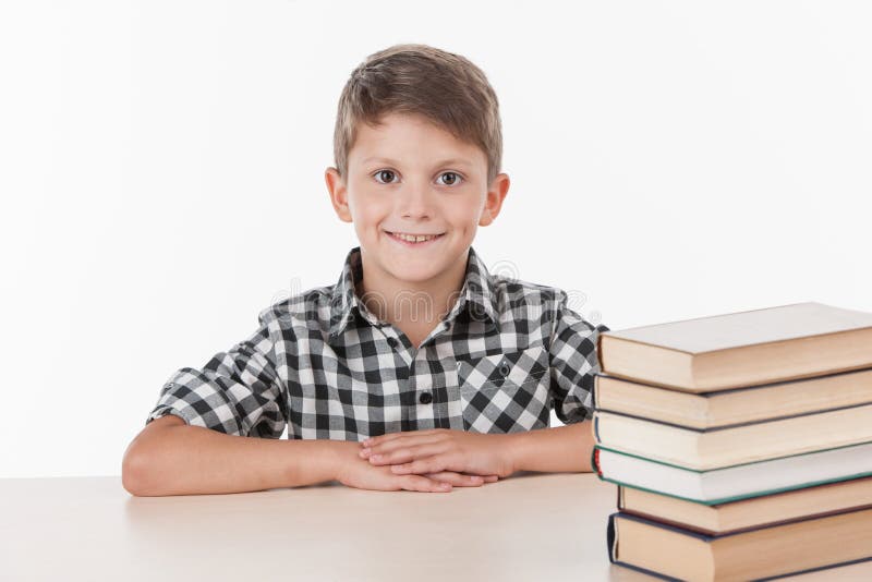 Cute boy sitting at table and smiling. stock photo