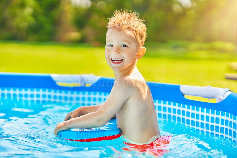 Cute Boy Swimming And Playing In A Backyard Pool Stock Photo Image of