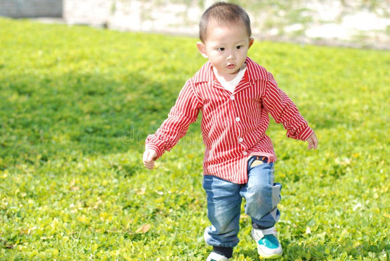 Cute boy walking on the lawn