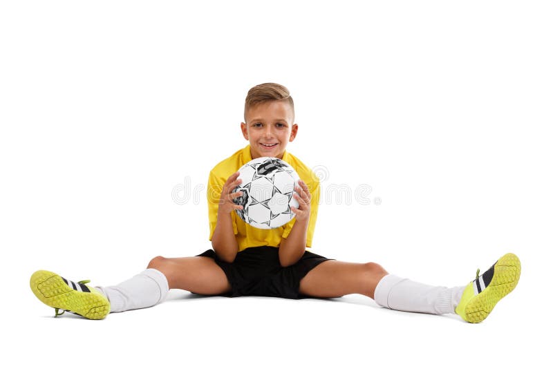 A cute boy in a yellow sports uniform holds a ball in his hands, young footballer isolated on a white background. stock photo A cute boy in a yellow sports uniform holds a ball in his hands, young footballer isolated on a white background. stock photo