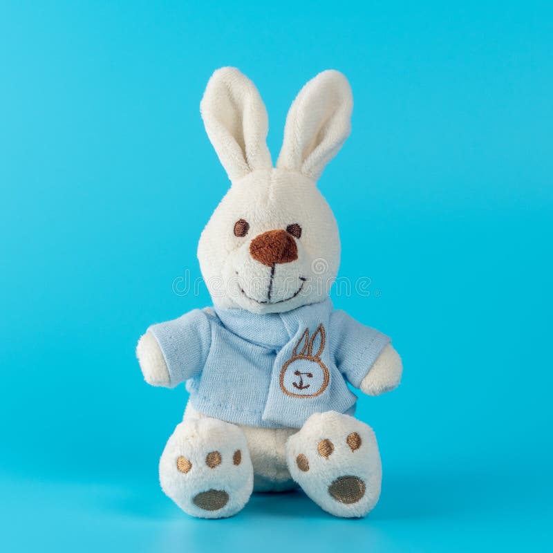 Cute bunny doll on blue background. Minimal Easter concept stock images