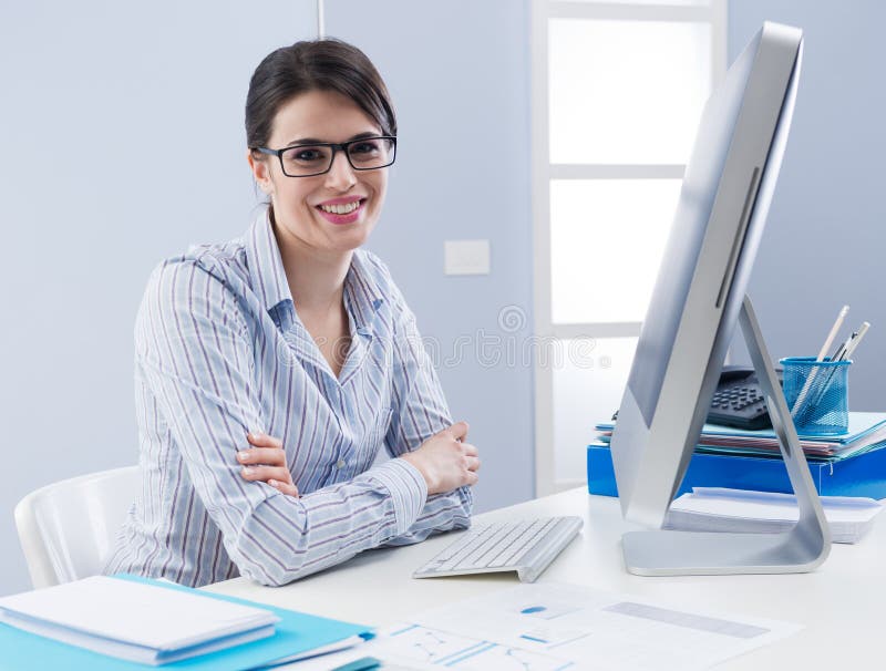 Cute businesswoman smiling at desk stock photo