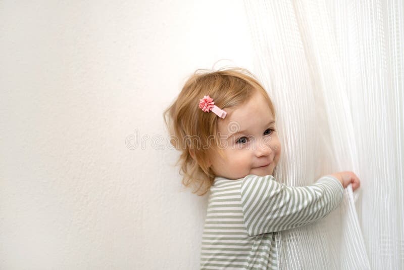 Cute Caucasian Blonde Baby Girl of 1,2 Year Old Playing with White Curtains, having Fun at Home in Light Interior Looking Stock Photo - Image of  indoors, stylish: 245336164