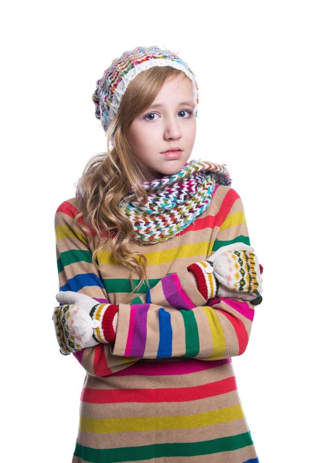 Cute cheerful teenage girl wearing colorful striped sweater, scarf, gloves and hat isolated on white background. Winter clothes.