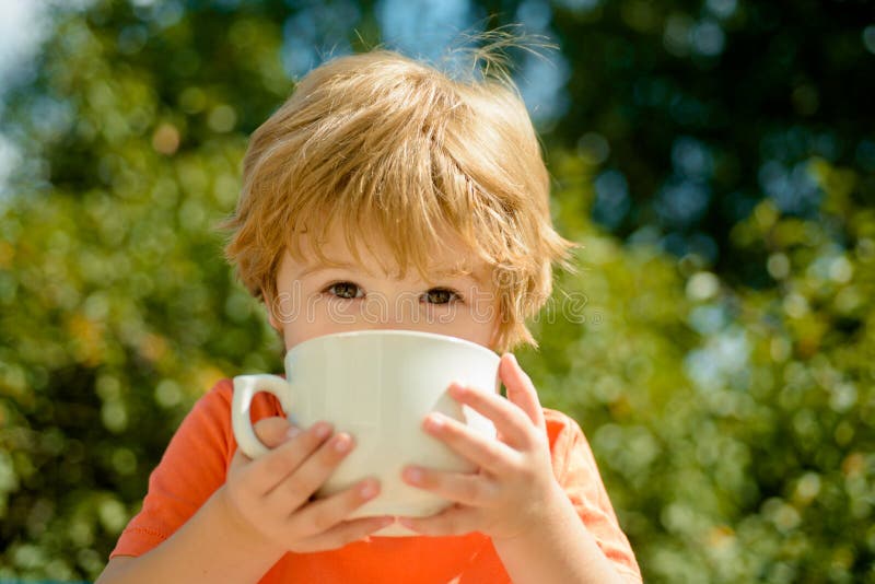 Cute child drinks milk. Healthy food and drink for children. Summer drinks. Baby boy and hot summer holidays. stock photo Cute child drinks milk. Healthy food and drink for children. Summer drinks. Baby boy and hot summer holidays. stock photo