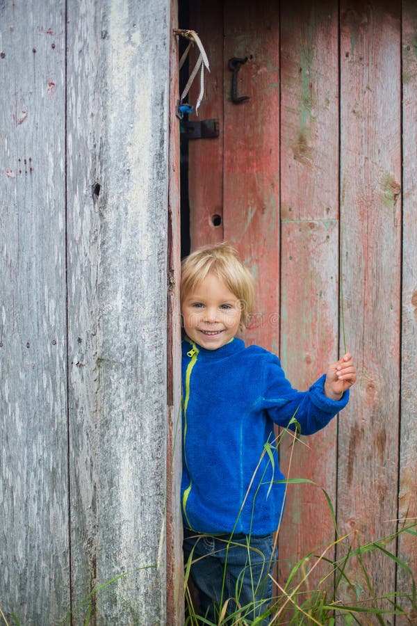 Cute Child, Peeping Behind an Old Door of Old Ruined Building in Norway ...