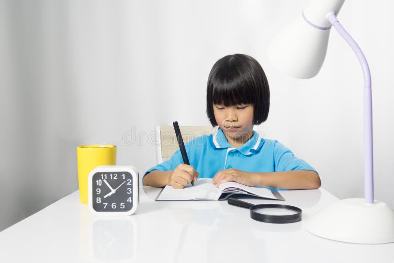 Cute child writing and working on work desk.