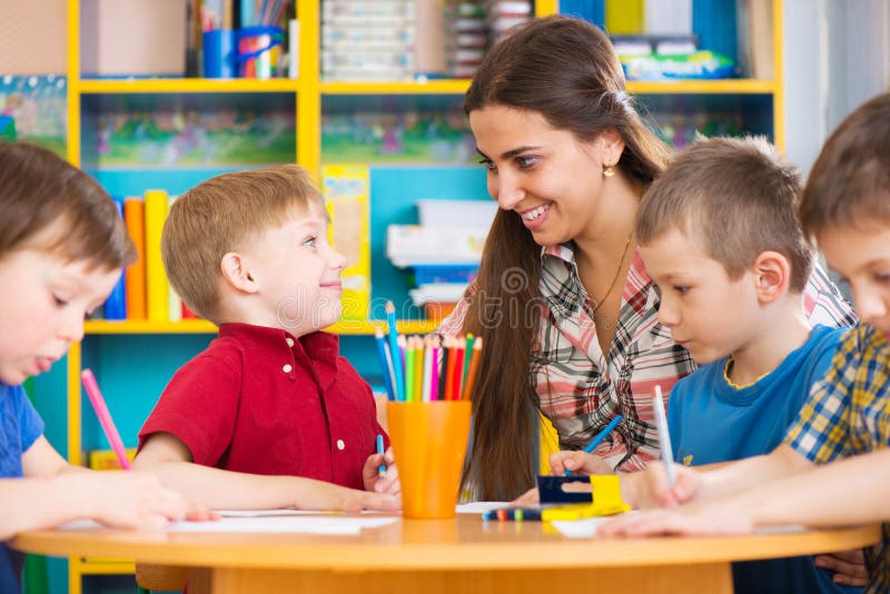 Cute children drawing with teacher at preschool class royalty free stock image