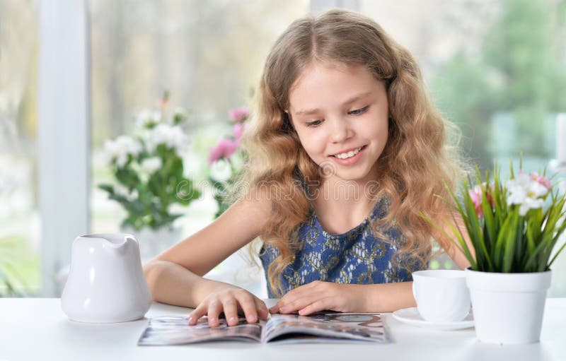 Little girl reading magazine