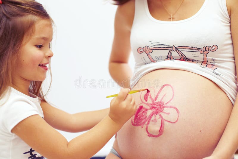 Cute daughter paint pregnant mother s belly