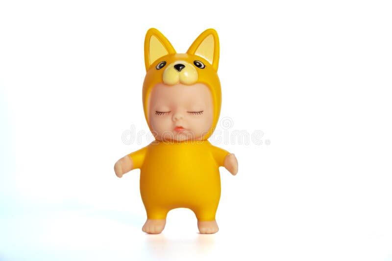 Cute doll in a fox costume with closed eyes. Stands on a white isolated background. Collection of toys. Soft focus.