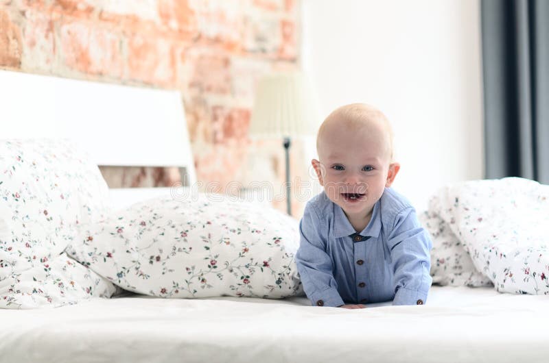Cute fun little boy is lying on the parent`s bed, laughing and i stock photos Cute fun little boy is lying on the parent`s bed, laughing and i stock photos