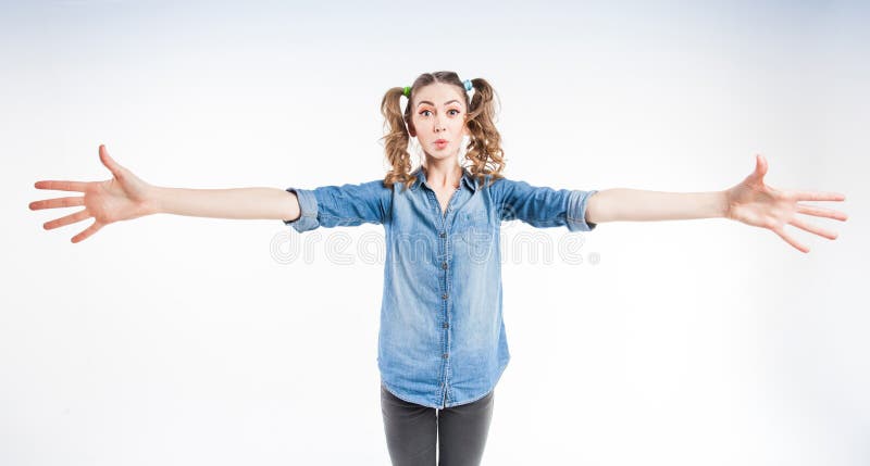 Cute funny girl with two pony tails showing how big it is - wide angle