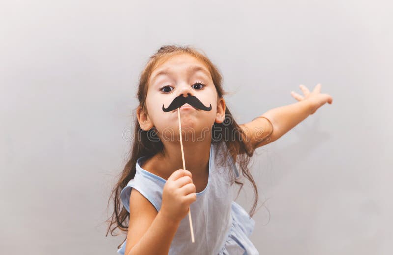 Cute funny little girl wearing paper mustache stock images Cute funny little girl wearing paper mustache stock images