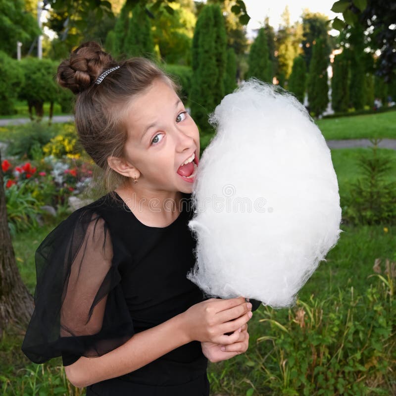 Cute Girl Bites Delicious Cotton Candy and Has Fun in t