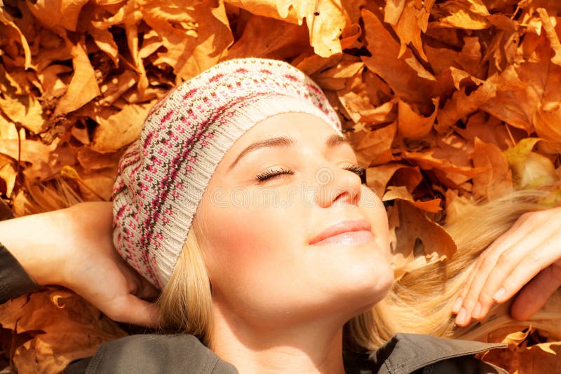 Cute girl dreaming on autumn leaves