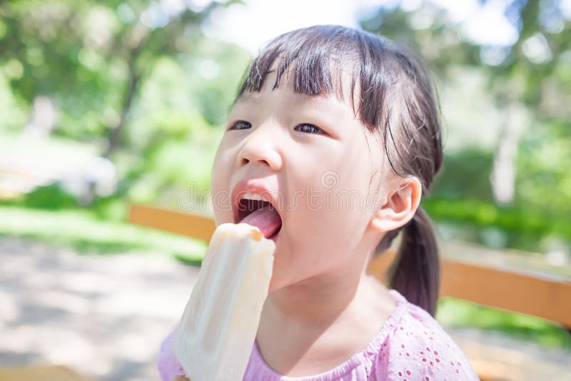 Cute girl eat popsicle in the park,asian