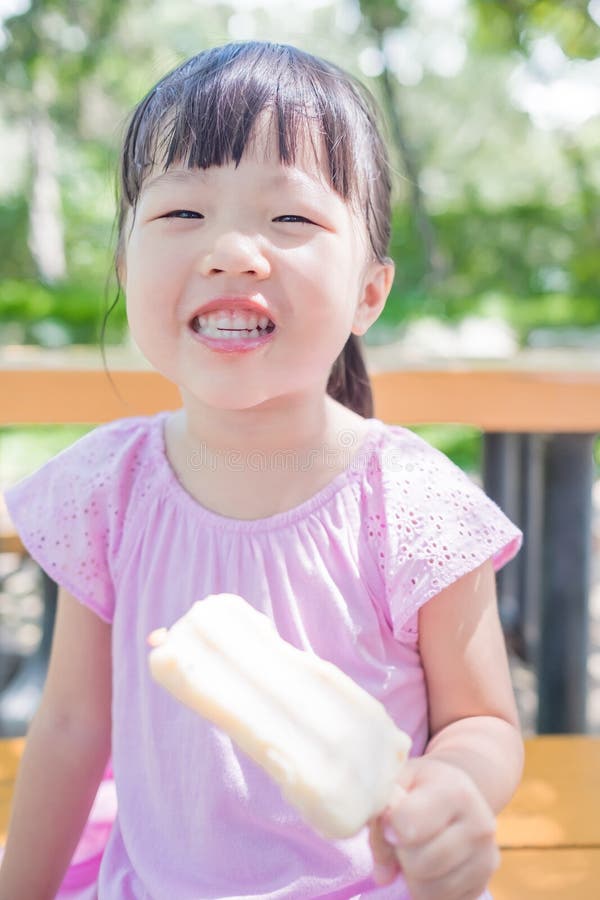 Cute girl eat popsicle in the park,asian