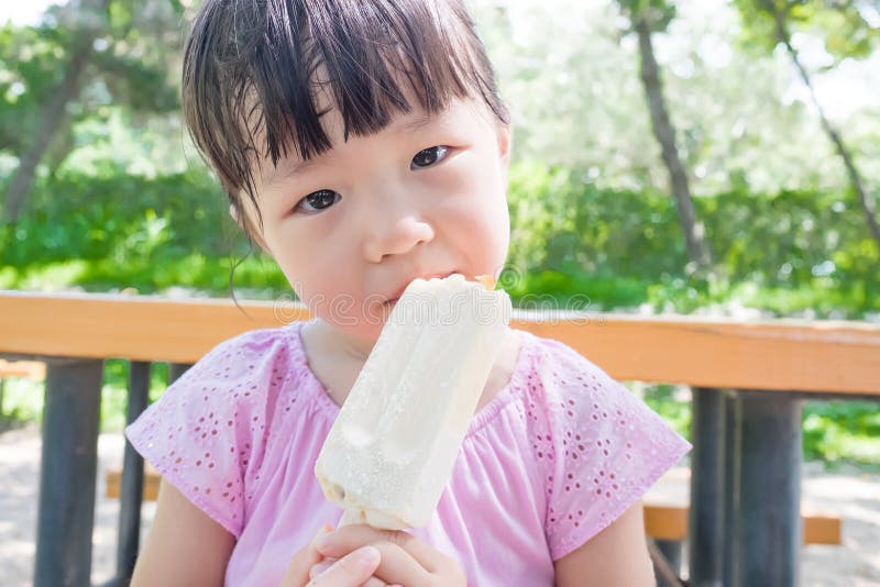 Cute girl eat popsicle in the park,asian