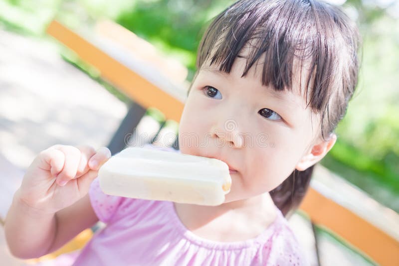 Cute girl eat popsicle in the park,asian