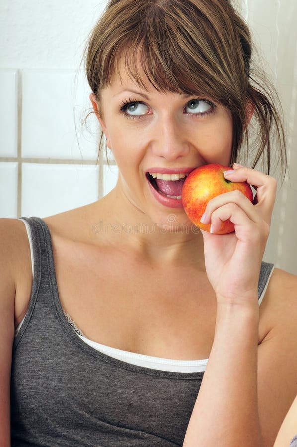 Cute girl eating a red apple