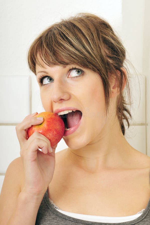 Cute girl eating a red apple