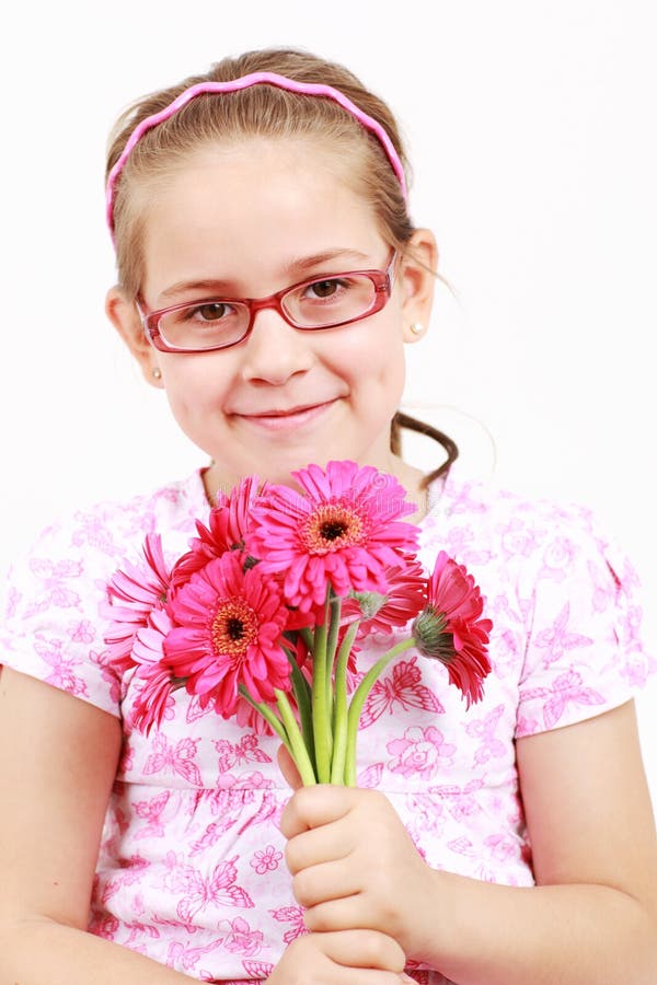 Ragazza carina in rosa con i fiori per la mamma o il papà il Giorno.