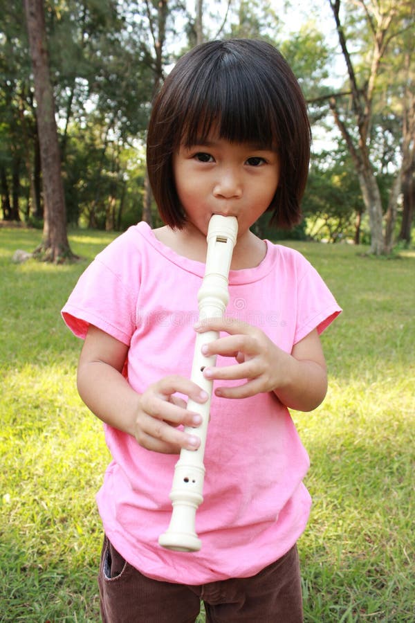 Cute girl playing flute stock photo. Image of childhood 32768196