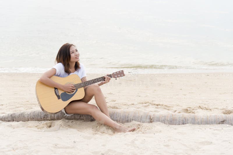 Cute girl playing guitar on the beach. Travel Concept stock photography Cute girl playing guitar on the beach. Travel Concept stock photography