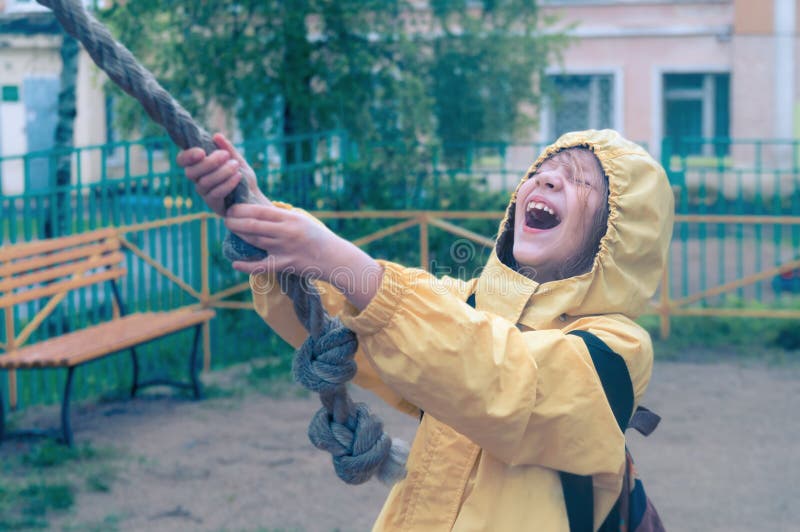 Cute girl plays in the playground in the rain royalty free stock photos