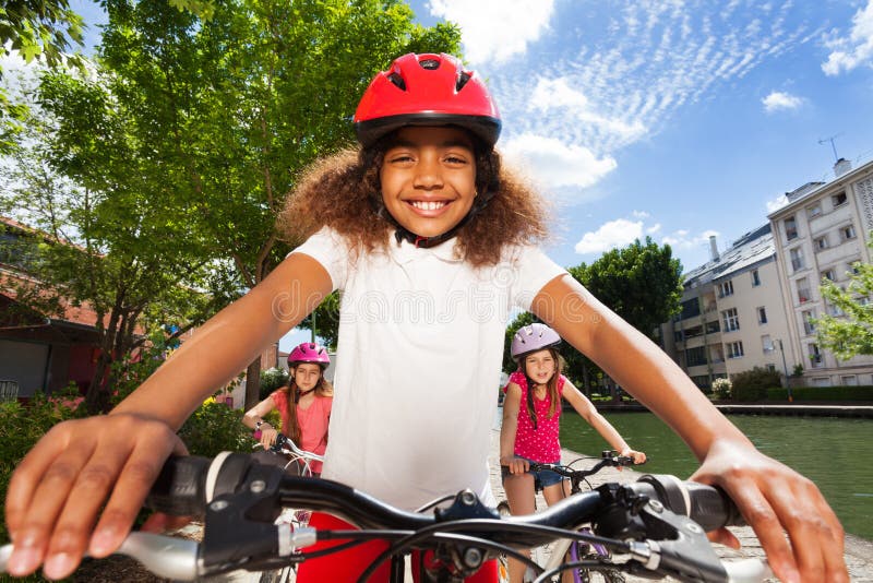 Cute girl riding bike along the river embankment