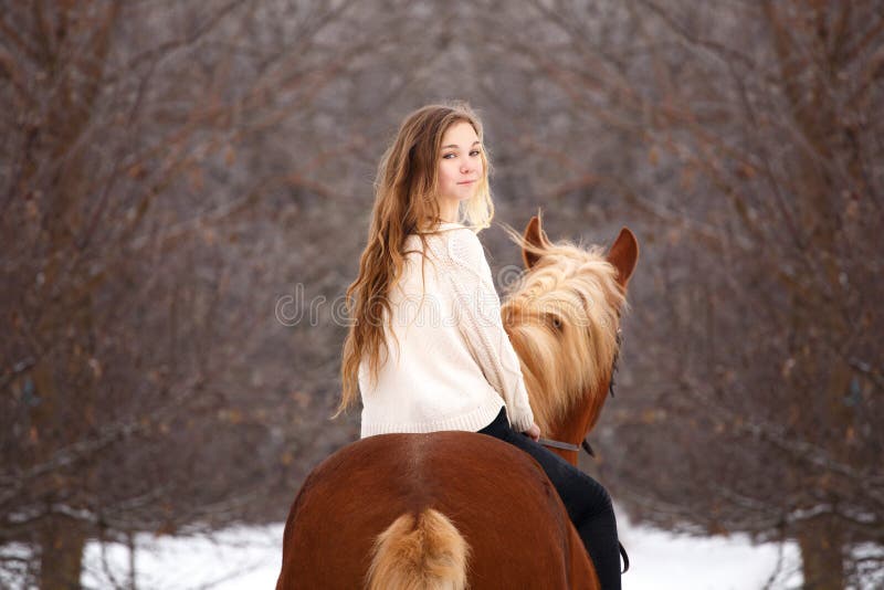 Cute girl riding horse looking back over shoulder